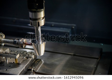 The sinker EDM machine simulate operation with the sample parts. The mould and die manufacturing process by Electrode Discharge Machine,EDM with the copper material electrode. Royalty-Free Stock Photo #1612945096