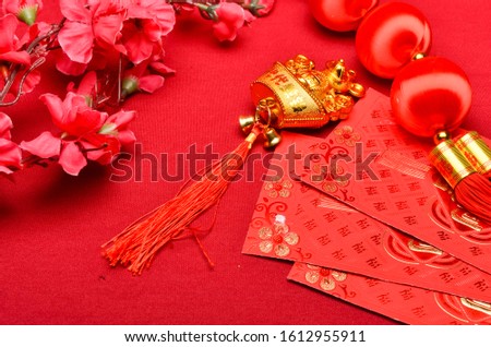 Chinese New Year decorations with red background with assorted festival decorations. Chinese characters means abundant of wealth, prosperity and luck. Selective focus.