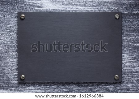 wooden nameplate or wall sign at wooden background texture surface, with screws