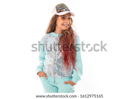 attractive girl with long colored hair with a casual sports suit and a baseball cap on a white background with copy space