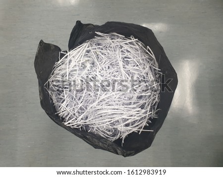 Shredded paper in black trash bag