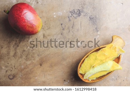 Raw organic dried mango and fresh ripe mango fruit on rustic table. Healthy eating,raw food or diet concept. Top view. Flat lay