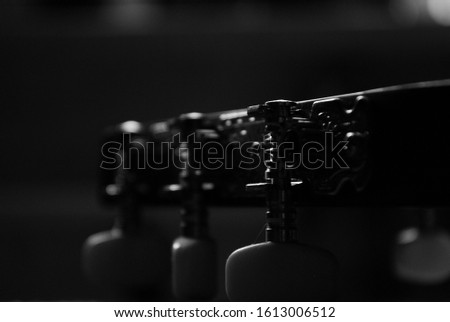 black and white close-up photo of a musical instrument guitar with strings and a male hand. for signage shop labels flyers advertising banners