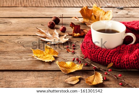 Hot coffee and autumn leaves on vintage wood background - seasonal relax concept