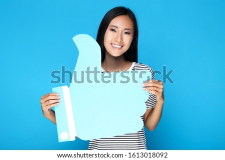 Beautiful woman holding paper Like on blue background