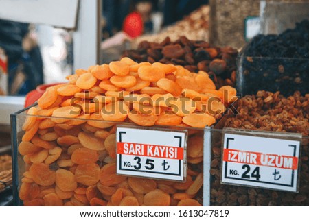 Selling dried apricots and raisins and other essential fruits on a market in Istanbul in Turkey. The inscription in Turkish is translated as dried apricots, another inscription is Izmir raisins.