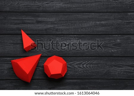 Paper geometric figures on black wooden table