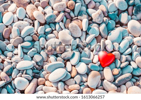 Valentines Day concept. Romantic love symbol of red heart on the pebble beach with copy space. Template for Inspirational compositions and quote postcards.