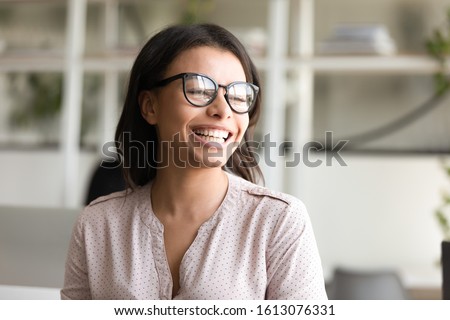 Head shot young cheerful African ethnicity businesswoman posing at workplace looking aside. Company owner leader portrait, successful employee, woman in business, intern girl, got job of dream concept Royalty-Free Stock Photo #1613076331