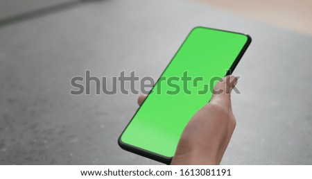 young woman holding smartphone over terrazzo countertop