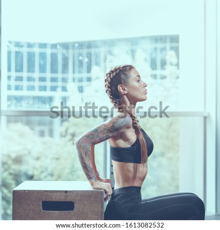 Portrait of muscular athletic woman doing box squat,
