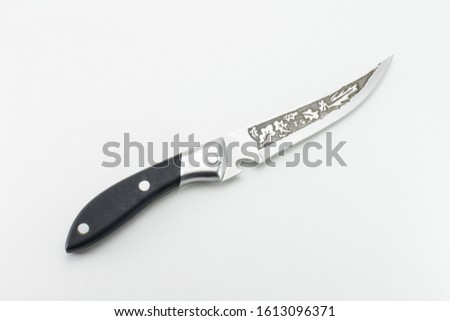 

An old kitchen knife with a black handle and an etched pattern on the blade. Vintage blade with oak leaf patterns. Electrolysis method. White isolated background.