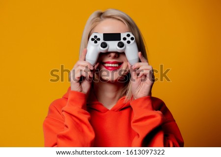 gamer girl with white gamepad on yellow background