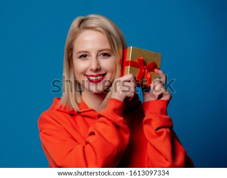 girl holds gift box on blue background