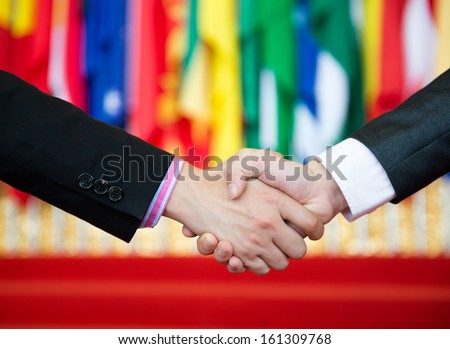 Businessmen shaking hands in front of the multi - national flag.    international business Royalty-Free Stock Photo #161309768