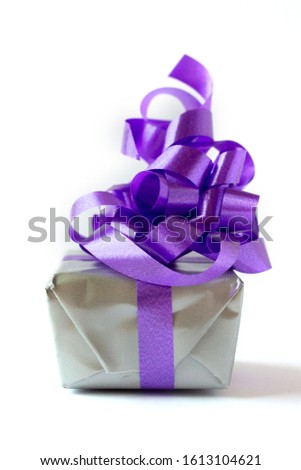 small gift box whit purple ribbon on white background