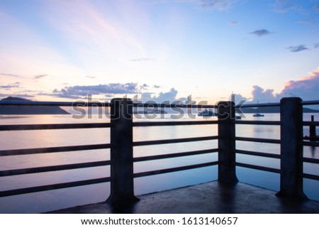 long exposure picture through fence of bridge in the blue morning scenery,  Rawai beach, Phuket, Thailand