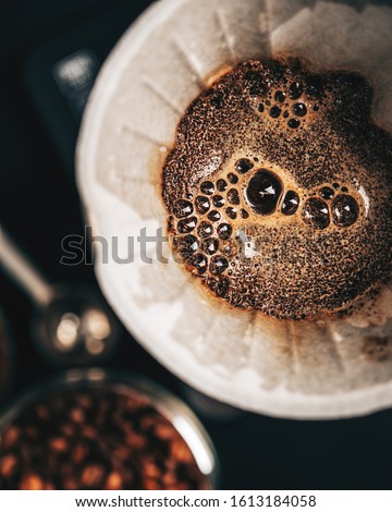 The process of making coffee by the alternative method of purover, paper filter, top view,dark background Royalty-Free Stock Photo #1613184058