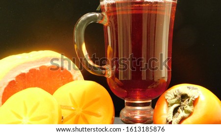 tropical fruits and a glass of juice close-up on a black background 