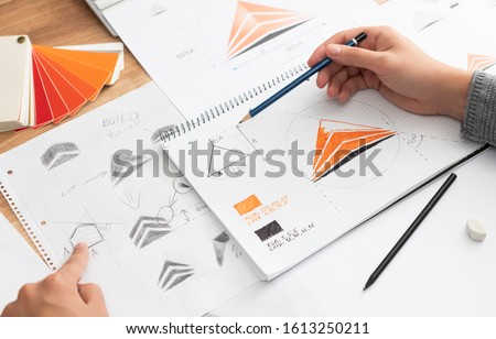 Graphic designer drawing sketches logo design. The concept of a new brand. Professional creative occupation with idea. Royalty-Free Stock Photo #1613250211