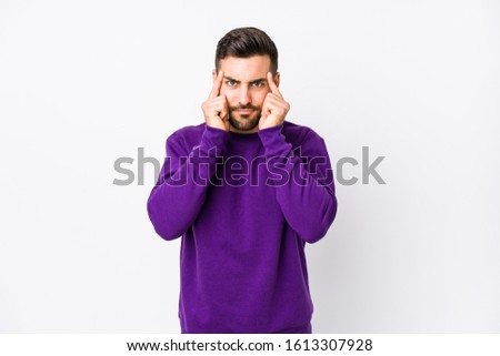 Young caucasian man against a white background isolated focused on a task, keeping forefingers pointing head.