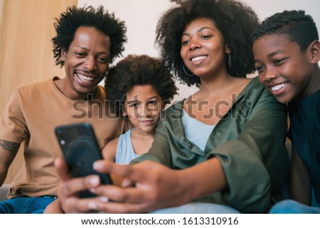Portrait of African American family taking a selfie together with mobile phone at home. Family and lifestyle concept.