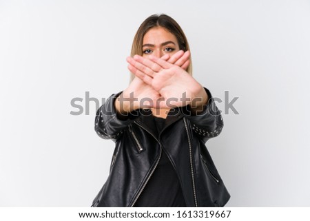 Young caucasian woman wearing a black leather jacket doing a denial gesture