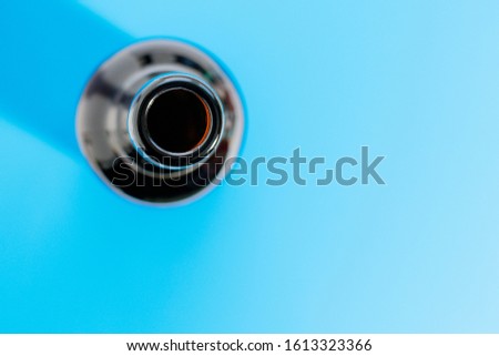 Empty dark bottle without cork and label on a blue background