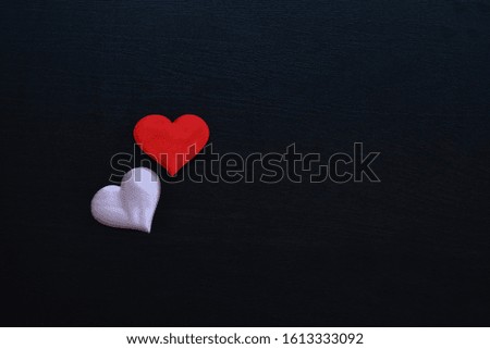
two red and pink wooden hearts on a black background. Valentines day - background