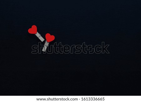 
two wooden hearts from clothespins on a black background. Valentine's Day