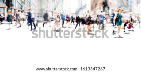Lots of business people walking in the City of London. Blurred image, wide panoramic view of the crossroad with people at sunny day. London, UK