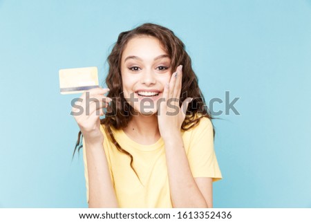 Surprised happy woman with yellow credit card holding it isolated.