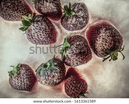 Abstract background of appetizing frozen strawberries with a texture of hoarfrost and ice.