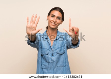 Young woman over isolated background counting seven with fingers