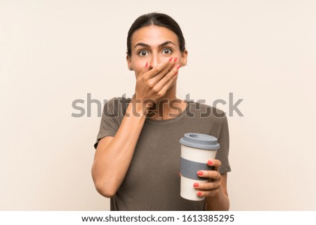 Young woman holding a take away coffee with surprise facial expression
