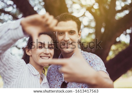 Couple in love making shape square with hands and looking camera at nature,Happy moments together