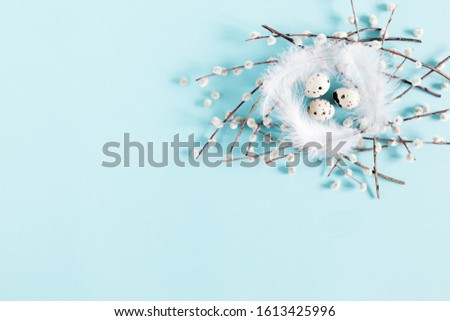 Easter holiday composition. Easter eggs and willow branch on pastel blue background. Flat lay, top view, copy space