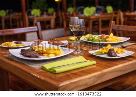 Steak dishes with potatoes and salad served on the restaurant table