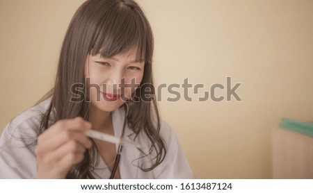 selected focus Asian female doctor is holding and looking thermometer medical temperature
