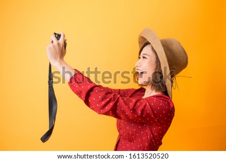 Happy pretty woman take a selfie picture by camera on orange background, asian beauty