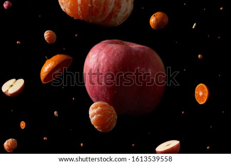 In front of a black background, fruit forms the universe space.