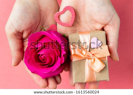gift box and flower in hands. Valentine's Day gift