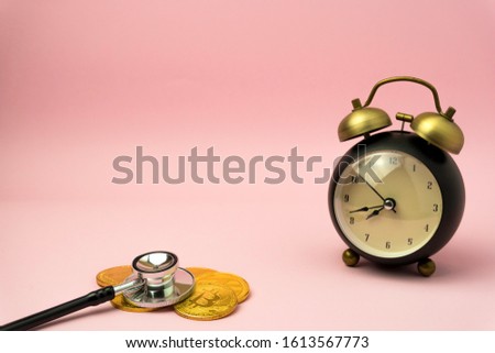 Time to make money concept, pink retro styled alarm clock on heap of american dollars. Banking, Savings, Wealth.