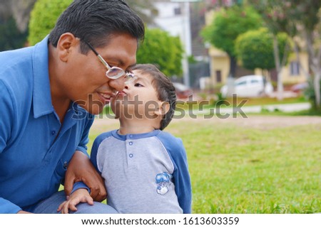 Tender portrait of native american man with his little son in the park. Royalty-Free Stock Photo #1613603359