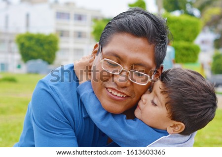 Tender portrait of native american man with his little son in the park. Royalty-Free Stock Photo #1613603365