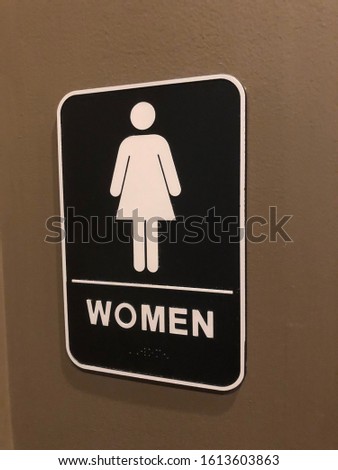 Women’s bathroom sign with gender icon and text description