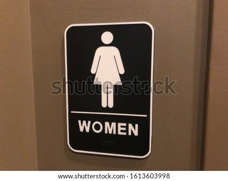 Women’s bathroom sign with gender icon and text description