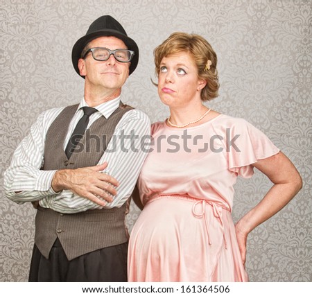 Proud 1950s man with bored pregnant woman