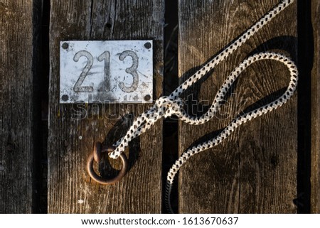 a metal board with the number two hundred and thirty and a place to moor the ship in the morning light