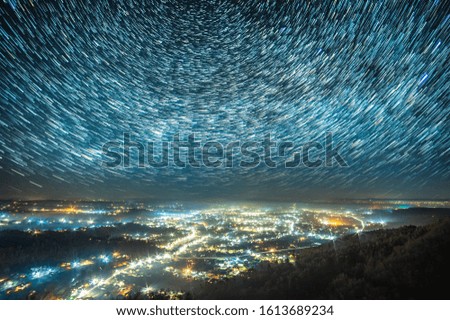 Starry sky over a night city in the Carpathian mountains